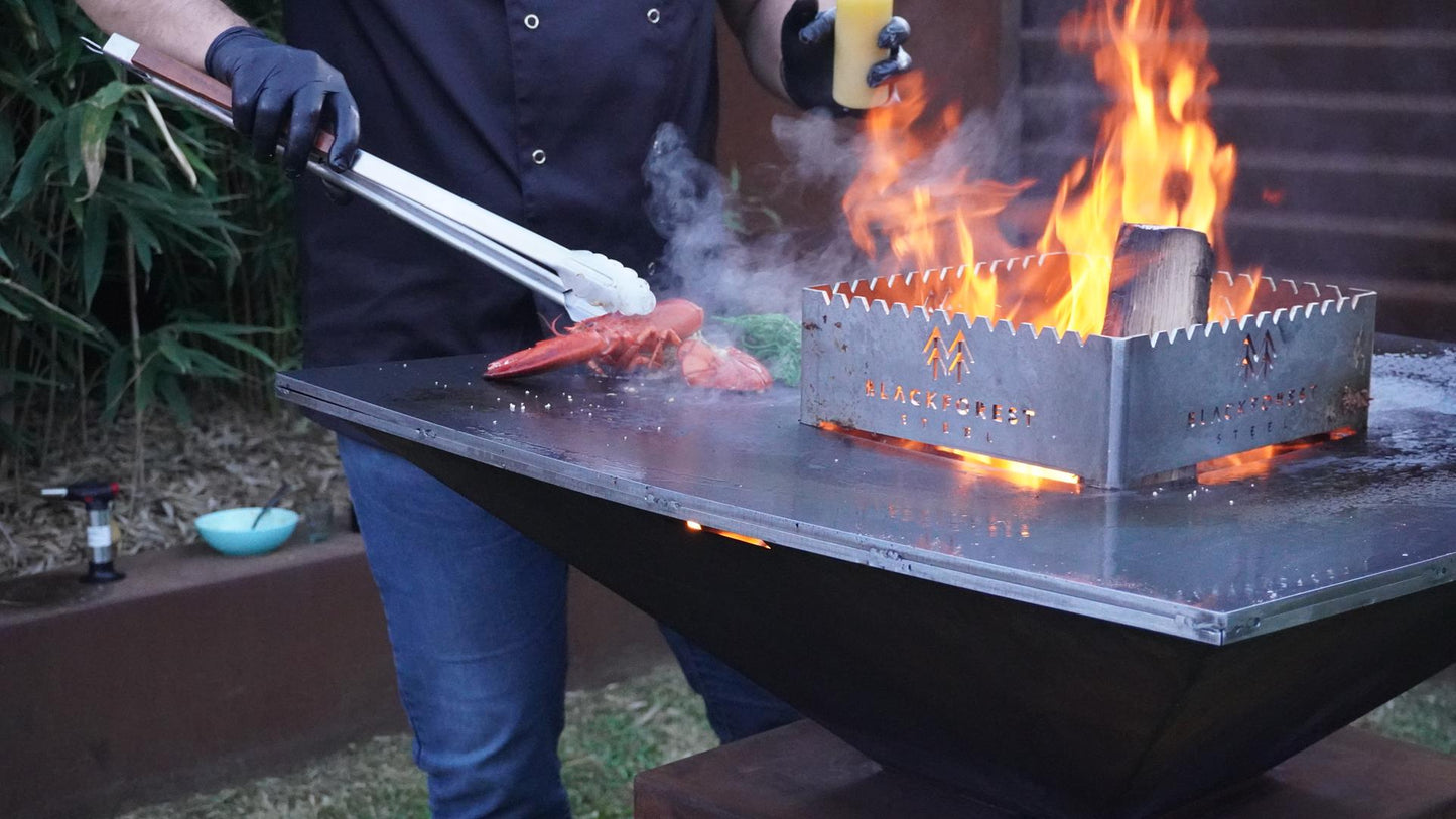Cortenstahl Feuerplattengrill mit Fleisch, Gemüse und offener Flamme